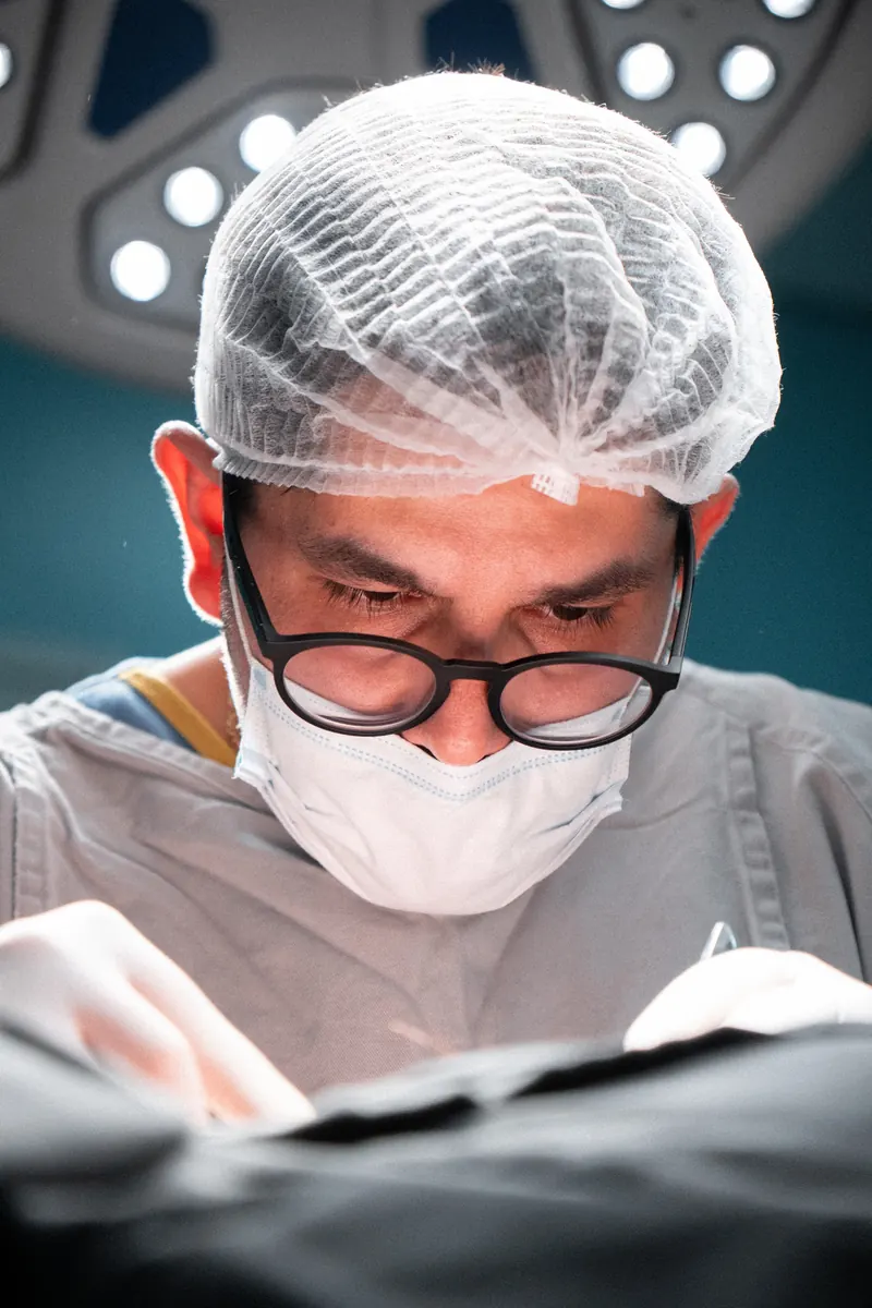 Dr. John Terrazas durante um procedimento, com as mãos em primeiro plano